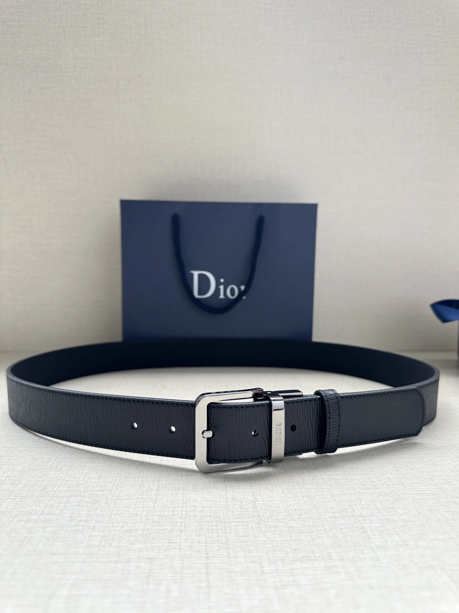 这款 35 毫米腰带融合典雅气质与 Dior 的摩登风范 双面牛皮设计 采用光滑牛皮革制作 另一面为黑色 金色饰面黄铜腰带扣搭配镌刻有 DIOR 标志的腰带环 精致高雅 可与各式正装搭配提升格调