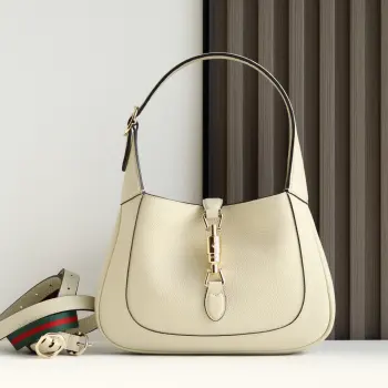 2024秋冬系列焕新演绎Gucci Jackie 1961系列肩背包 采用精细古驰安可拉红 Rosso Ancora 皮革制作 搭配全新浅金色调推入式锁扣开合 彰显品牌经典手袋的精湛工艺 新月造型和流畅廓形 这款小号肩背包搭配皮革肩带 另附红绿织带肩带 成就多样穿搭选择 型号 810232 尺寸 27.5 宽 x 19 高 x 4厘米 深 颜色 荔枝纹米白原厂皮 