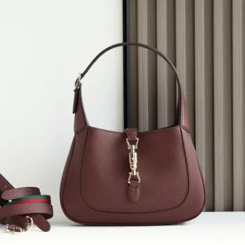 2024秋冬系列焕新演绎Gucci Jackie 1961系列肩背包 采用精细古驰安可拉红 Rosso Ancora 皮革制作 搭配全新浅金色调推入式锁扣开合 彰显品牌经典手袋的精湛工艺 新月造型和流畅廓形 这款小号肩背包搭配皮革肩带 另附红绿织带肩带 成就多样穿搭选择 型号 810232 尺寸 27.5 宽 x 19 高 x 4厘米 深 颜色 荔枝纹安可拉红原厂皮 