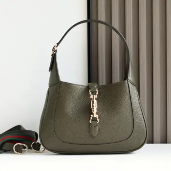 2024秋冬系列焕新演绎Gucci Jackie 1961系列肩背包 采用精细古驰安可拉红 Rosso Ancora 皮革制作 搭配全新浅金色调推入式锁扣开合 彰显品牌经典手袋的精湛工艺 新月造型和流畅廓形 这款小号肩背包搭配皮革肩带 另附红绿织带肩带 成就多样穿搭选择 型号 810232 尺寸 27.5 宽 x 19 高 x 4厘米 深 颜色 荔枝纹墨绿原厂皮 