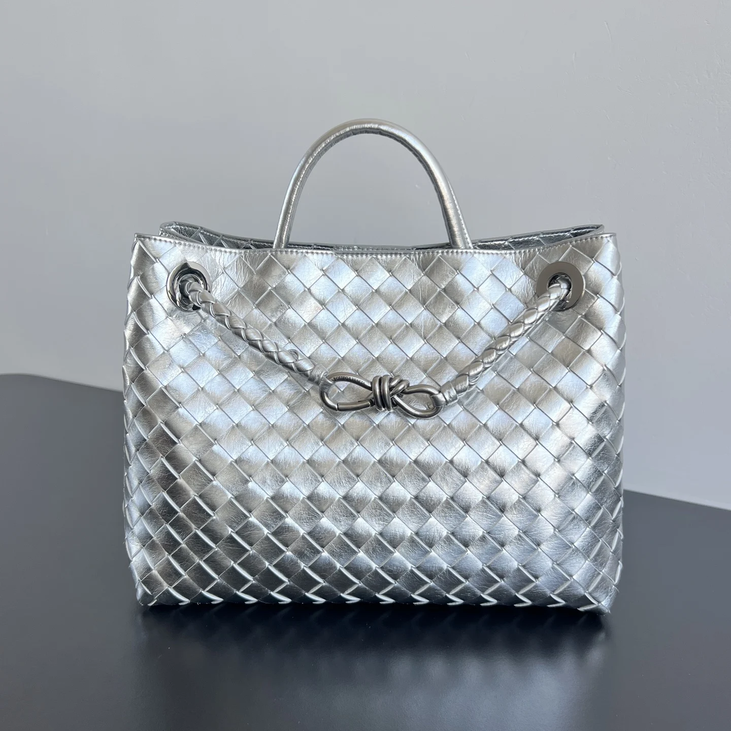 Bottega Veneta Andiamo银色编织手袋  众多明星同款  743572  眼前一亮又一亮的感觉 太高级啦 搭配金色绳结扣 够沉稳也够潇洒整体皆由Nappa羊皮革制成 舒适柔软且富有动感 可滑动的金属绳结扣可以调整肩带 单肩 手伶 斜挎 多种背法 包身容量大 通勤 日常 出游都很合适 这款包分为小号 中号  大号 总有一款适合你  那就带我走叭  尺寸:32.5x24x12