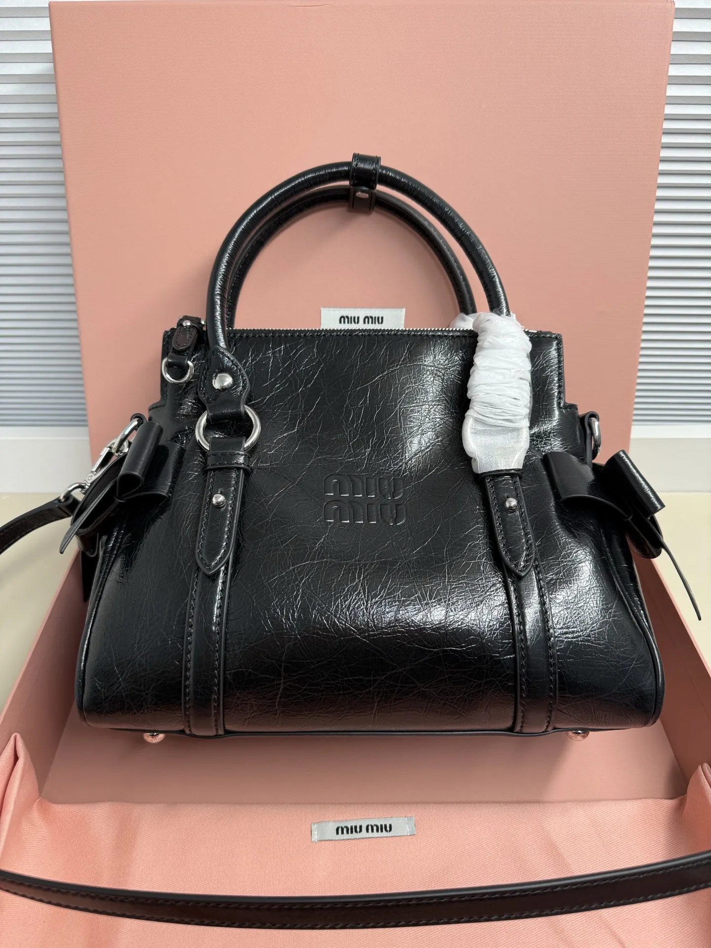<p>Miu Miu 26SS RIBBON 早春手袋 经典 一看到就想到miu初代的经典 当一对翅膀决定同时栖落在 历史与此刻的肩头 真正的经典永远在时间的两端同时生长中古银扣锁着未褪的鎏金梦 硬壳机车包型+蝴蝶结 这两个八杆子打不着的关系撞在一起 居然毫无违和感 有点机车有点可爱 甜和飒同时拉满 自重很轻 亮面牛皮革材质</p><p>型号 5BA327</p><p>尺寸 28*15*22cm70</p>