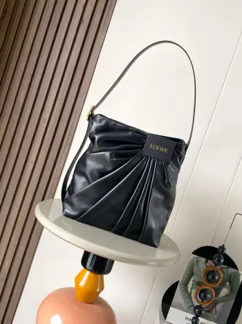 <p> 新款  柔软纳帕羊皮革Draped手袋 Draped 手袋别具一格 灵感源自L0 EWE 标志性成衣的垂坠廓形 柔软的雕塑感造型 搭配宽肩带 饰有镌刻L0  EWE 标志的醒目搭扣 此版本采用柔软纳帕羊皮革制成 *可肩背或斜挎*可调节肩带*磁扣开合 一个内部牛皮革贴袋*人字纹棉质帆布衬里*L0  EWE烫金</p><p>尺寸 30CM 29CM 13CM</p><p>款号 9156</p><p>颜色 黑色</p>