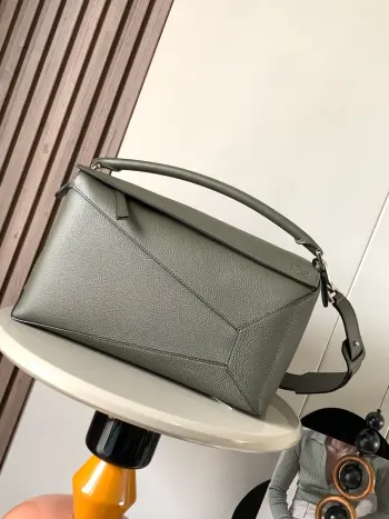 <p> 新款大号几何包36CM Puzzle手袋 原厂进口荔枝纹牛皮   罗家爆款几何包 Puzzle 手袋是创意总监乔纳森 安德森  Jonathan Anderson  为 L0 EWE 推出的首款手提包包 长方体形状和精确的切割技术创造了 Puzzle 独特的几何线条 简约大气的几何设计时髦中带着股酷劲 可甜可盐 原厂荔枝纹小牛皮 包型都不变型 手感舒适得没话说上身气质立马up 立体包型还蕴藏着非凡的容量 是永远都囤不够的热门单品 </p><p>尺寸 36CM 23CM 19CM</p><p>款号 9054</p><p>颜色 卡其绿荔</p>
