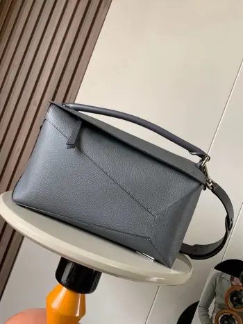 <p> 新款大号几何包36CM Puzzle手袋 原厂进口荔枝纹牛皮   罗家爆款几何包 Puzzle 手袋是创意总监乔纳森 安德森  Jonathan Anderson  为 L0 EWE 推出的首款手提包包 长方体形状和精确的切割技术创造了 Puzzle 独特的几何线条 简约大气的几何设计时髦中带着股酷劲 可甜可盐 原厂荔枝纹小牛皮 包型都不变型 手感舒适得没话说上身气质立马up 立体包型还蕴藏着非凡的容量 是永远都囤不够的热门单品 </p><p>尺寸 36CM 23CM 19CM</p><p>款号 9054</p><p>颜色 煤灰荔</p>