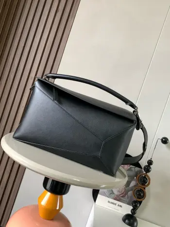 <p> 新款大号几何包36CM Puzzle手袋 原厂进口荔枝纹牛皮   罗家爆款几何包 Puzzle 手袋是创意总监乔纳森 安德森  Jonathan Anderson  为 L0 EWE 推出的首款手提包包 长方体形状和精确的切割技术创造了 Puzzle 独特的几何线条 简约大气的几何设计时髦中带着股酷劲 可甜可盐 原厂荔枝纹小牛皮 包型都不变型 手感舒适得没话说上身气质立马up 立体包型还蕴藏着非凡的容量 是永远都囤不够的热门单品 </p><p>尺寸 36CM 23CM 19CM</p><p>款号 9054</p><p>颜色 黑色平纹</p>