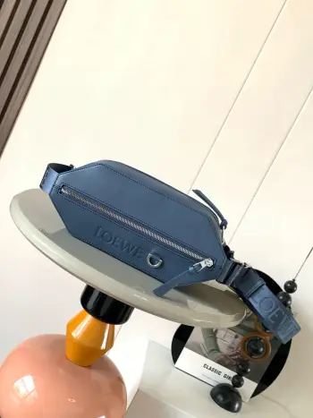 <p>经典牛皮革变形 Sling 手袋 紧凑型 Sling 手袋配有可调节 LOE WE 织带和品牌标志金属搭扣 可打开以改变手袋容量并实现多种携带方式 外部拉链平口袋进步增强了功能性 这个版本采用经典牛皮 革制成  可斜挎或作为腰包携带  拉链开合 牛皮革拉链头 人字纹棉质帆布衬里 配有 D 形环的压纹 LOE WE </p><p>尺寸 32.5cm 9cm 12.3cm</p><p>款号 9074</p><p>颜色 靛蓝色</p>