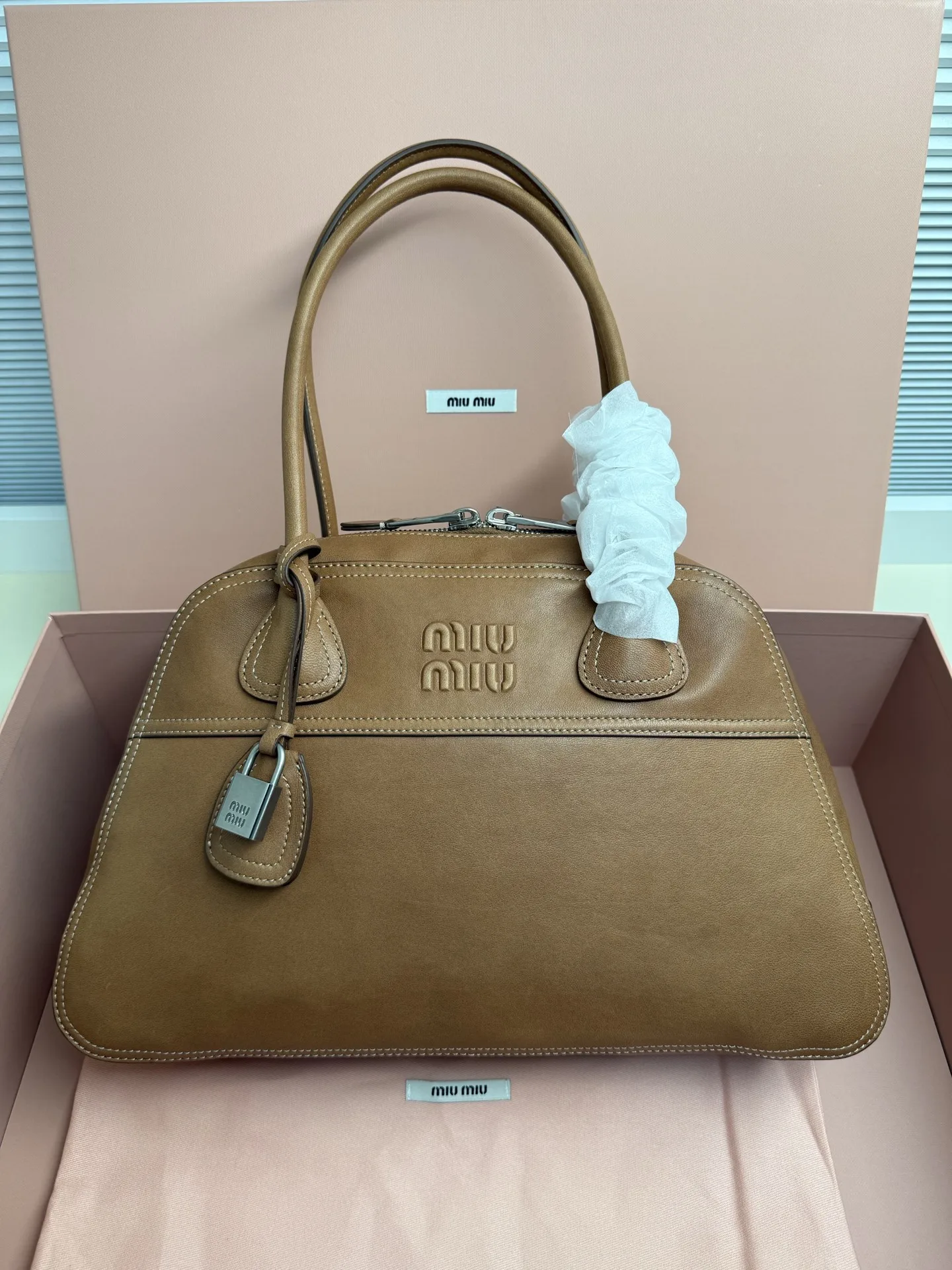 <p>Miu Miu Vivant 植鞣小羊皮 写给时间的反叛情书 中号 40cm 的容量被植鞣皮撑起饱满的弧度 它装得下职场必备 却因小羊皮的自然垂坠感而毫无 工具包 的笨重 这是给 既要效率也要美感 的知识分子的答案 </p><p> 型号 5BB196</p><p> 尺寸 40*24*13cm</p>