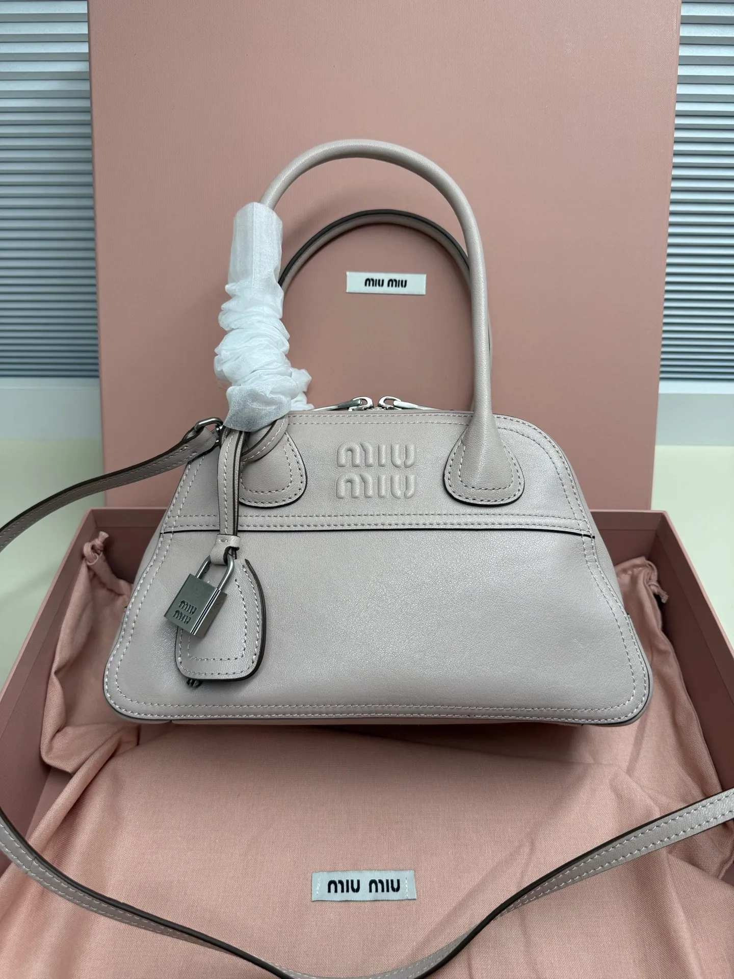 <p> Miu Miu Vivant 迷你 选用细腻绒面牛皮革 哑光质感像抚摸一片柔软的云 光线掠过时 泛起微醺般的光晕 高级感拉满 经典保龄球包型 麂皮让原本立体的线条变得柔和慵懒 自然垂坠出 不刻意 的时髦感 同色系浮雕 Logo 若隐若现 搭配做旧金属挂锁 麂皮的软糯与金属的冷冽 碰撞出独特的 甜酷 张力</p><p> 型号 5BB200</p><p> 尺寸 28*17*9.5cm</p>