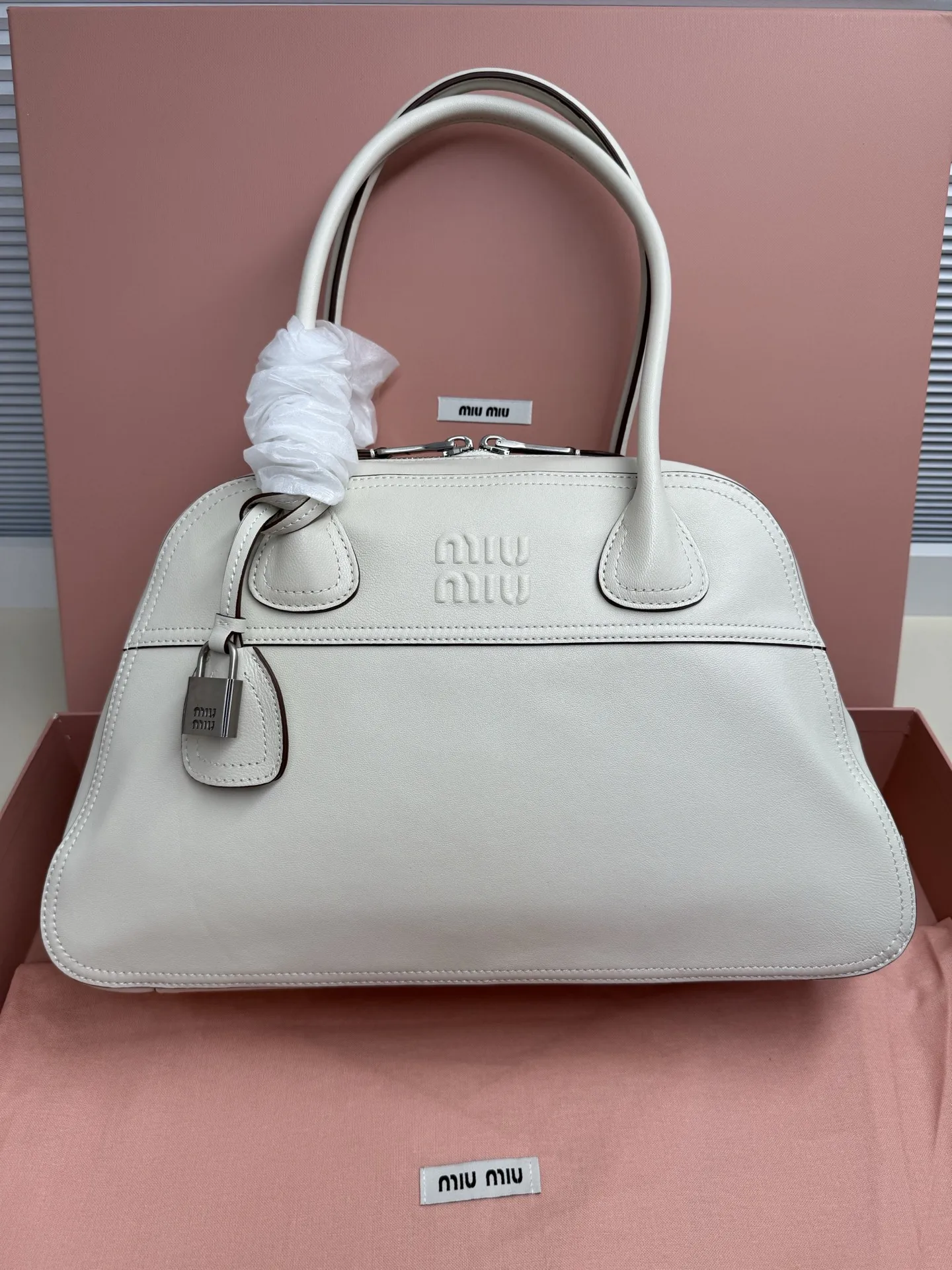 <p>Miu Miu Vivant 植鞣小羊皮 写给时间的反叛情书 中号 40cm 的容量被植鞣皮撑起饱满的弧度 它装得下职场必备 却因小羊皮的自然垂坠感而毫无 工具包 的笨重 这是给 既要效率也要美感 的知识分子的答案 </p><p> 型号 5BB196</p><p> 尺寸 40*24*13cm</p>