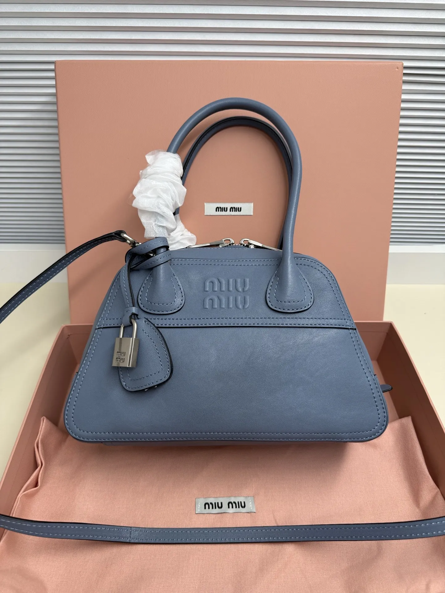 <p> Miu Miu Vivant 迷你 选用细腻绒面牛皮革 哑光质感像抚摸一片柔软的云 光线掠过时 泛起微醺般的光晕 高级感拉满 经典保龄球包型 麂皮让原本立体的线条变得柔和慵懒 自然垂坠出 不刻意 的时髦感 同色系浮雕 Logo 若隐若现 搭配做旧金属挂锁 麂皮的软糯与金属的冷冽 碰撞出独特的 甜酷 张力</p><p> 型号 5BB200</p><p> 尺寸 28*17*9.5cm</p>