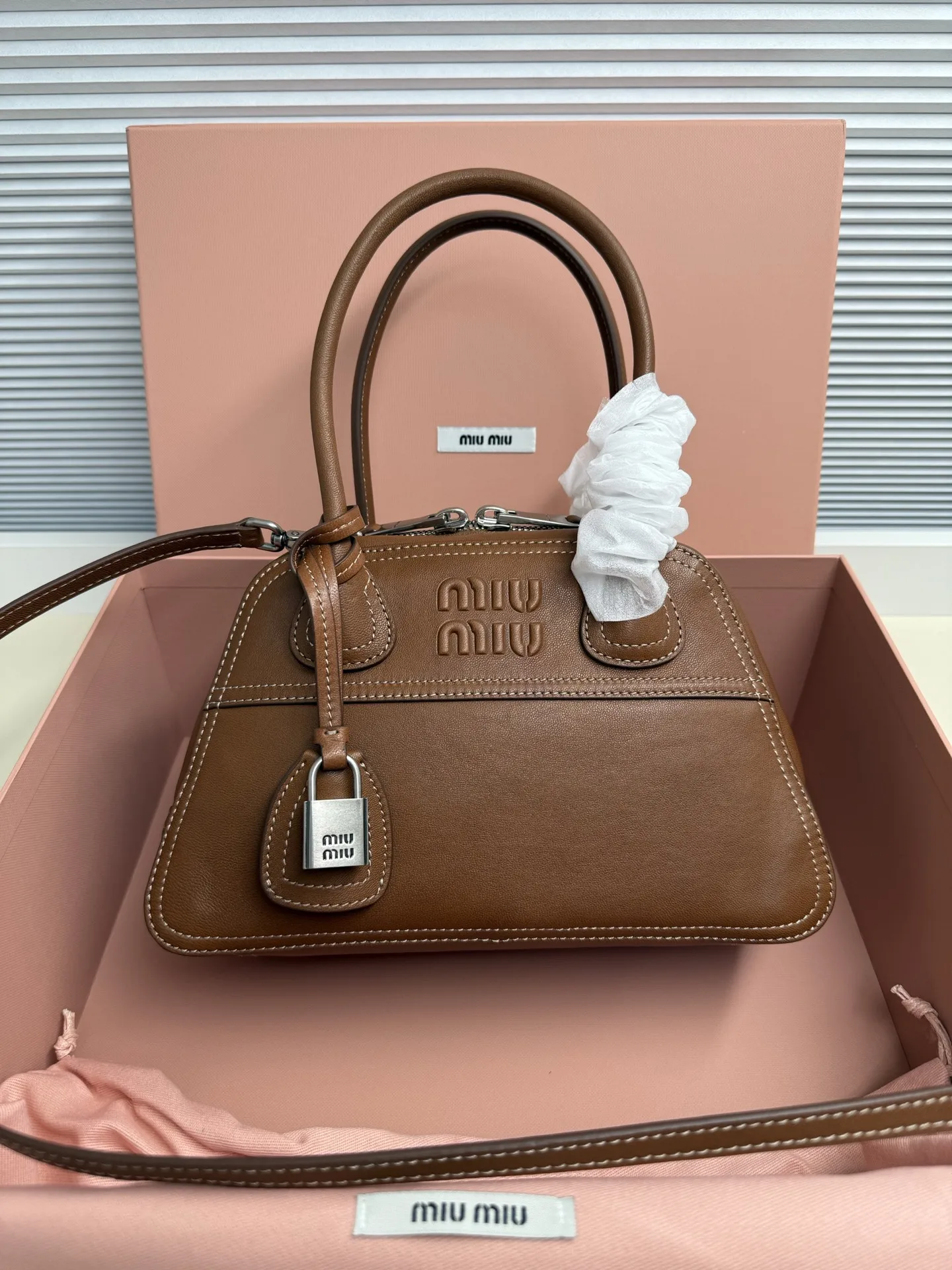 <p> Miu Miu Vivant 迷你 选用细腻绒面牛皮革 哑光质感像抚摸一片柔软的云 光线掠过时 泛起微醺般的光晕 高级感拉满 经典保龄球包型 麂皮让原本立体的线条变得柔和慵懒 自然垂坠出 不刻意 的时髦感 同色系浮雕 Logo 若隐若现 搭配做旧金属挂锁 麂皮的软糯与金属的冷冽 碰撞出独特的 甜酷 张力</p><p> 型号 5BB200</p><p> 尺寸 28*17*9.5cm</p>