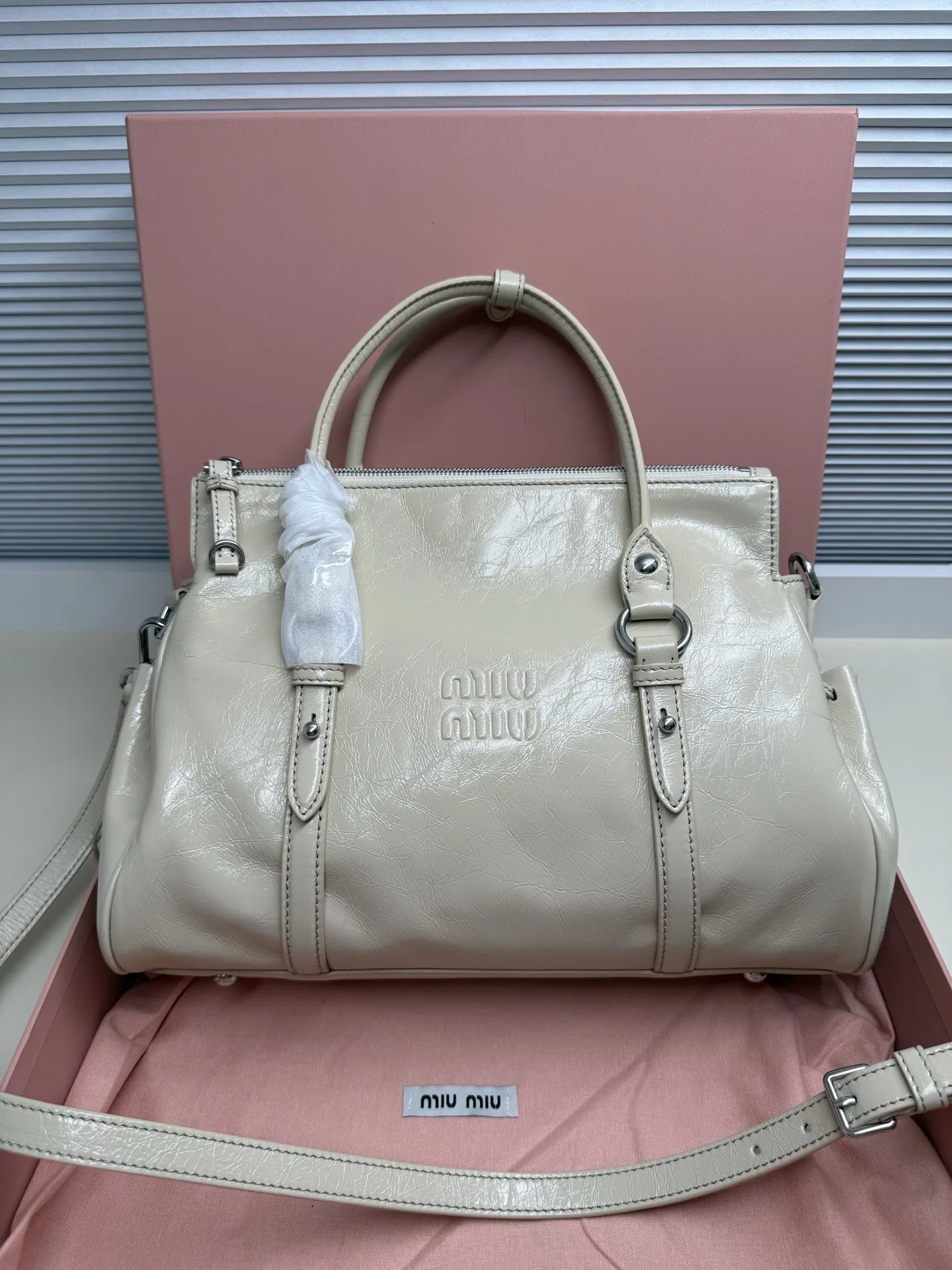<p> Miumiu26早春新款油蜡皮机车包 </p><p>这款是油蜡牛皮的 </p><p>国内上的是蝴蝶结 版的</p><p>欧洲这款把蝴蝶结改成了褶皱抽绳</p><p>有长肩带可以斜挎 尺寸 </p><p>大号35*19*16cm 款号328</p>