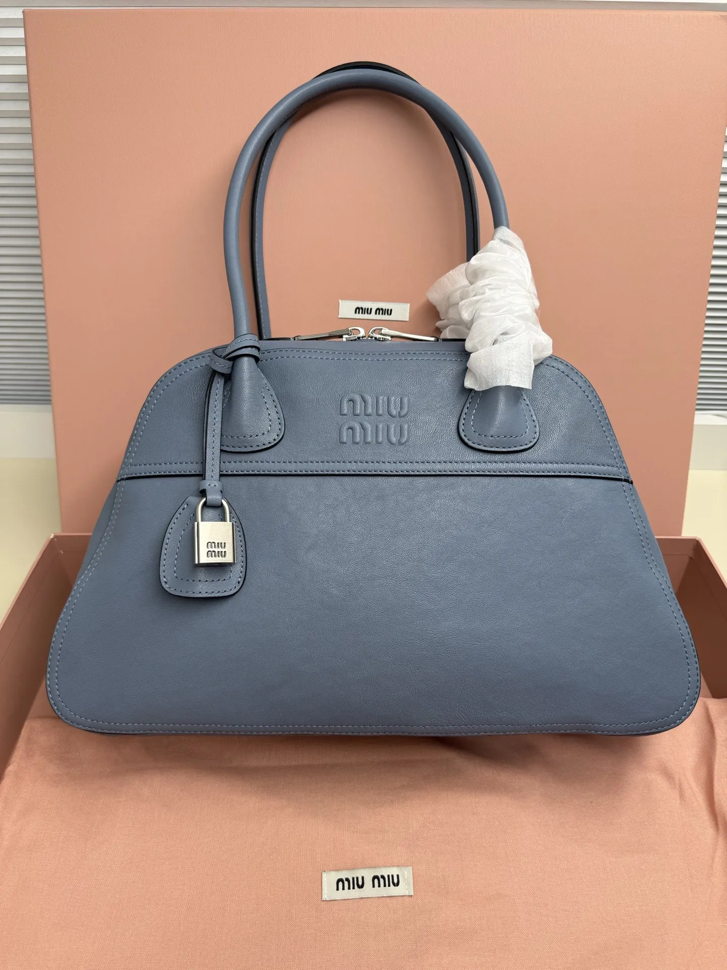 <p>Miu Miu Vivant 植鞣小羊皮 写给时间的反叛情书 中号 40cm 的容量被植鞣皮撑起饱满的弧度 它装得下职场必备 却因小羊皮的自然垂坠感而毫无 工具包 的笨重 这是给 既要效率也要美感 的知识分子的答案 </p><p> 型号 5BB196</p><p> 尺寸 40*24*13cm</p>