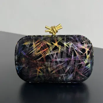 <p> BV新品晚宴包幻彩镭射线条在黑底上交错 金 紫 蓝 红流光溢彩 像把暗夜星河握在掌心搭配立体开扣利落显贵 开合间都是未来感仪式感 派对/潮酷穿搭都适配 低调又炸场</p><p>尺寸 18x11x5 </p>