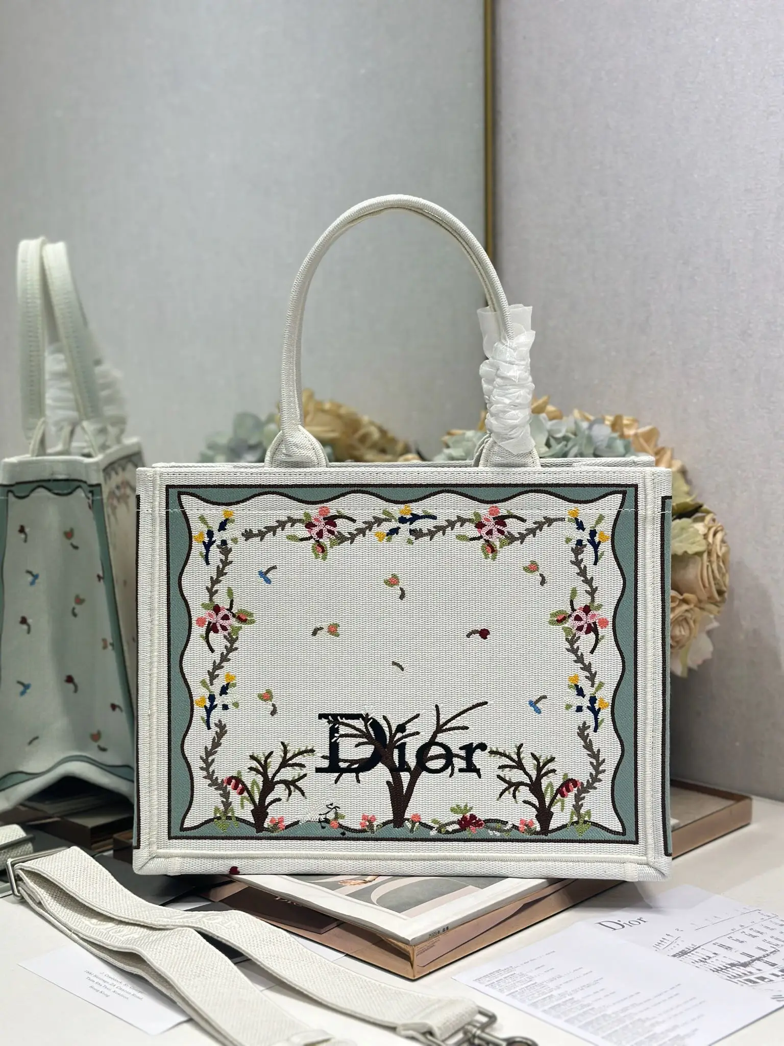 <p> 白咖啡树配肩带 中号尺寸 </p><p>Dior book tote 购物袋</p><p>这款Book Tote手袋灵感来自女装创意总监玛丽亚 嘉茜娅 蔻丽 Maria Grazia Chiuri 是体现Dior审美的主打产品 可收纳各种日常用品 全新演绎Bayadere图案混合效果D-Stripes图案刺绣 更具时尚风范 正面饰以 Christian Dior 标志 充分体现了Dior的精湛工艺 </p><p>款号 1286</p>