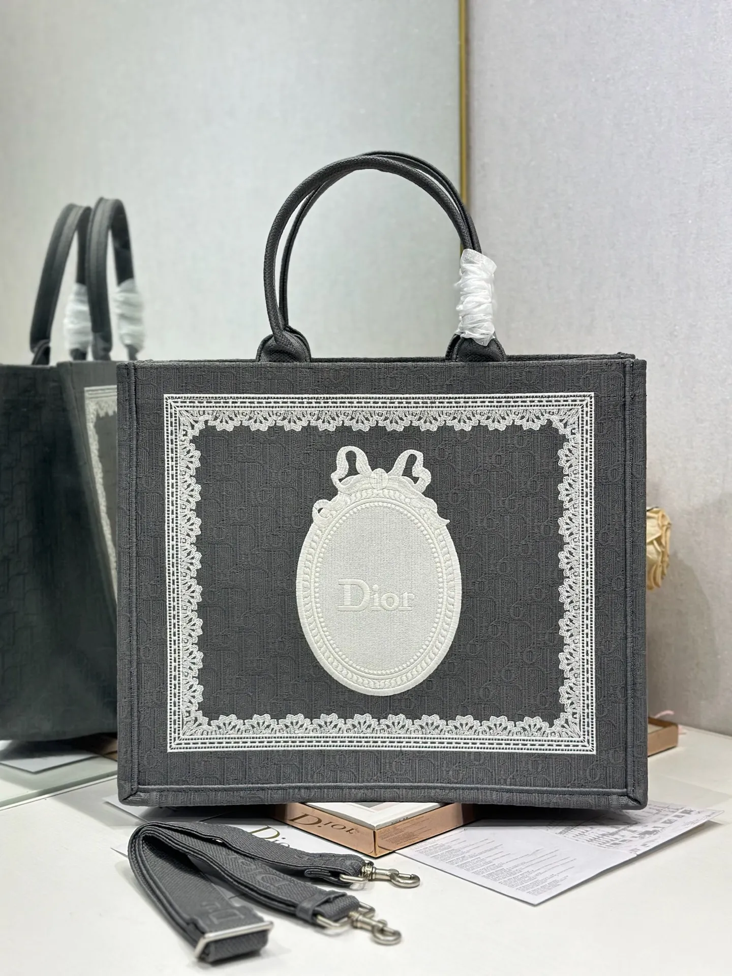 <p> 深灰D镜子配肩带 大号 </p><p>Dior book tote 购物袋</p><p>这款Book Tote手袋灵感来自女装创意总监玛丽亚 嘉茜娅 蔻丽 Maria Grazia Chiuri 是体现Dior审美的主打产品 可收纳各种日常用品 全新演绎Bayadere图案混合效果D-Stripes图案刺绣 更具时尚风范<p>款号 1286</p>