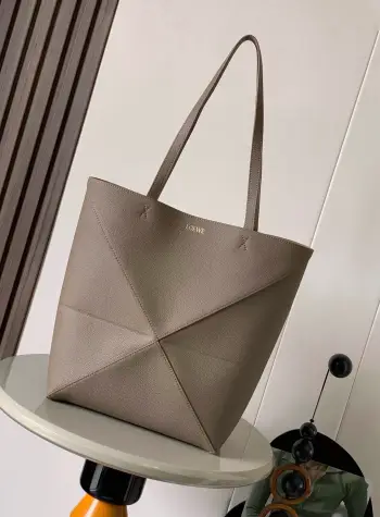 <p>新款荔面牛皮革puzzle Fold手袋又把几何图形玩出花了  很久没见过这么实用又设计感满满的托特包了这款延续了Puzzle系列的几何美学以折纸包为灵感 让这只 Puzzle Fold tote 在立体和平面随意切换上身了两个尺码<p>款号 9029</p><p>颜色 灰褐色荔</p>