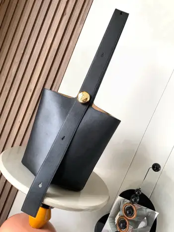 <p>中号柔软牛皮革 Pebble Bucket 水桶包是L0EWE极简主义的又一代表水桶包时尚简约且能装 Anagram金色鹅卵石配件是点睛之笔这个包的一个特点是肩带很宽所以它更适合斜挎或者像秀场男模特那样 把包单拎在后背<p>款号 9045</p><p>颜色 黑色</p>
