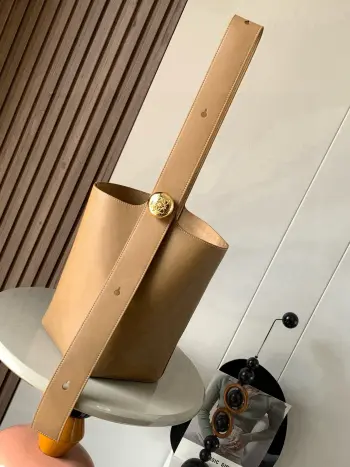 <p>中号柔软牛皮革 Pebble Bucket 水桶包是L0EWE极简主义的又一代表水桶包时尚简约且能装 Anagram金色鹅卵石配件是点睛之笔这个包的一个特点是肩带很宽所以它更适合斜挎或者像秀场男模特那样 把包单拎在后背<p>款号 9045</p><p>颜色 橡木棕</p>