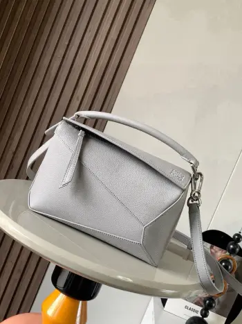 <p>新版本几何包小号24CMPuzzle手袋 原厂进口荔枝纹小牛皮罗家爆款几何包Puzzle 手袋是创意总监乔纳森 安德森为 L0EWE 推出的首款手提包长方体形状和精确的切割技术创造了 Puzzle 独特的几何线条<p>款号 8010 9311</p><p>颜色 灰色</p>
