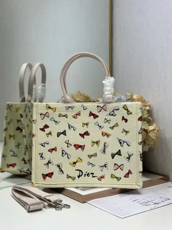  蝴蝶结配肩带 中号尺寸 Dior book tote 购物袋这款Book Tote手袋灵感来自女装创意总监玛丽亚 嘉茜娅 蔻丽 Maria Grazia Chiuri 是体现Dior审美的主打产品 可收纳各种日常用品 全新演绎Bayadere图案混合效果D-Stripes图案刺绣 更具时尚风范 正面饰以 Christian Dior 标志 充分体现了Dior的精湛工艺 款号 1286尺寸 36×28 cm 