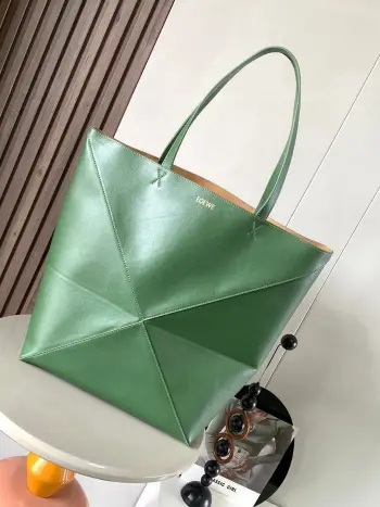大号新款亮面牛皮革购物袋puzzle Fold手袋大号几何图形玩出花了  很久没见过这么实用又设计感满满的托特包了这款延续了Puzzle系列的几何美学以折纸包为灵感 让这只 Puzzle Fold tote 在立体和平面随意切换上身了两个尺码给大家参考哦大号容量更友好 小号很可爱 皮质都很细腻光泽本身自重超轻 能完全折叠是旅行良伴 这个大号版本采用柔软的亮面牛皮革打造尺寸 42CM 41CM 18CM款号 9033颜色 猎人绿