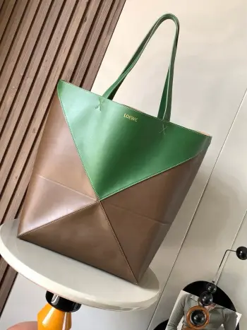 大号新款亮面牛皮革购物袋puzzle Fold手袋大号几何图形玩出花了  很久没见过这么实用又设计感满满的托特包了这款延续了Puzzle系列的几何美学以折纸包为灵感 让这只 Puzzle Fold tote 在立体和平面随意切换上身了两个尺码给大家参考哦大号容量更友好 小号很可爱 皮质都很细腻光泽本身自重超轻 能完全折叠是旅行良伴 这个大号版本采用柔软的亮面牛皮革打造尺寸 42CM 41CM 18CM款号 9033颜色 琥珀猎人绿