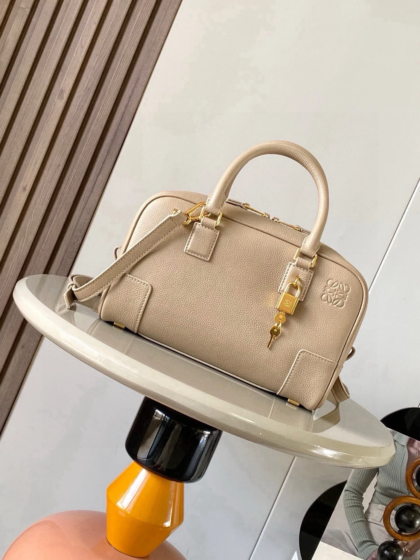 纳帕牛皮革 Amazona 23 手袋Amazona 是 LOEWE 的标志性手袋 最初于1970年代作为顶部提手软结构手袋推出这款纳帕牛皮革版本更新了精致的比例和细节 包括一个 Anagram 雕刻挂锁 斜挎 肩背或顶部提手携带 可拆卸可调节肩带 双拉链开合 牛皮革拉链头 内部拉链隔层和按扣固定的插袋 用于存放挂锁钥匙的迷你口袋 底部保护性金属脚 可以使用肩带和个性化挂饰进行定制 金色绒面革衬里  Anagram 压纹尺寸 23cm 10cm 15cm款号 9078颜色 沙色荔
