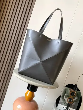 大号新款亮面牛皮革购物袋puzzle Fold手袋大号几何图形玩出花了  很久没见过这么实用又设计感满满的托特包了这款延续了Puzzle系列的几何美学以折纸包为灵感 让这只 Puzzle Fold tote 在立体和平面随意切换上身了两个尺码给大家参考哦大号容量更友好 小号很可爱 皮质都很细腻光泽本身自重超轻 能完全折叠是旅行良伴 这个大号版本采用柔软的亮面牛皮革打造尺寸 42CM 41CM 18CM款号 9033颜色 深灰咖
