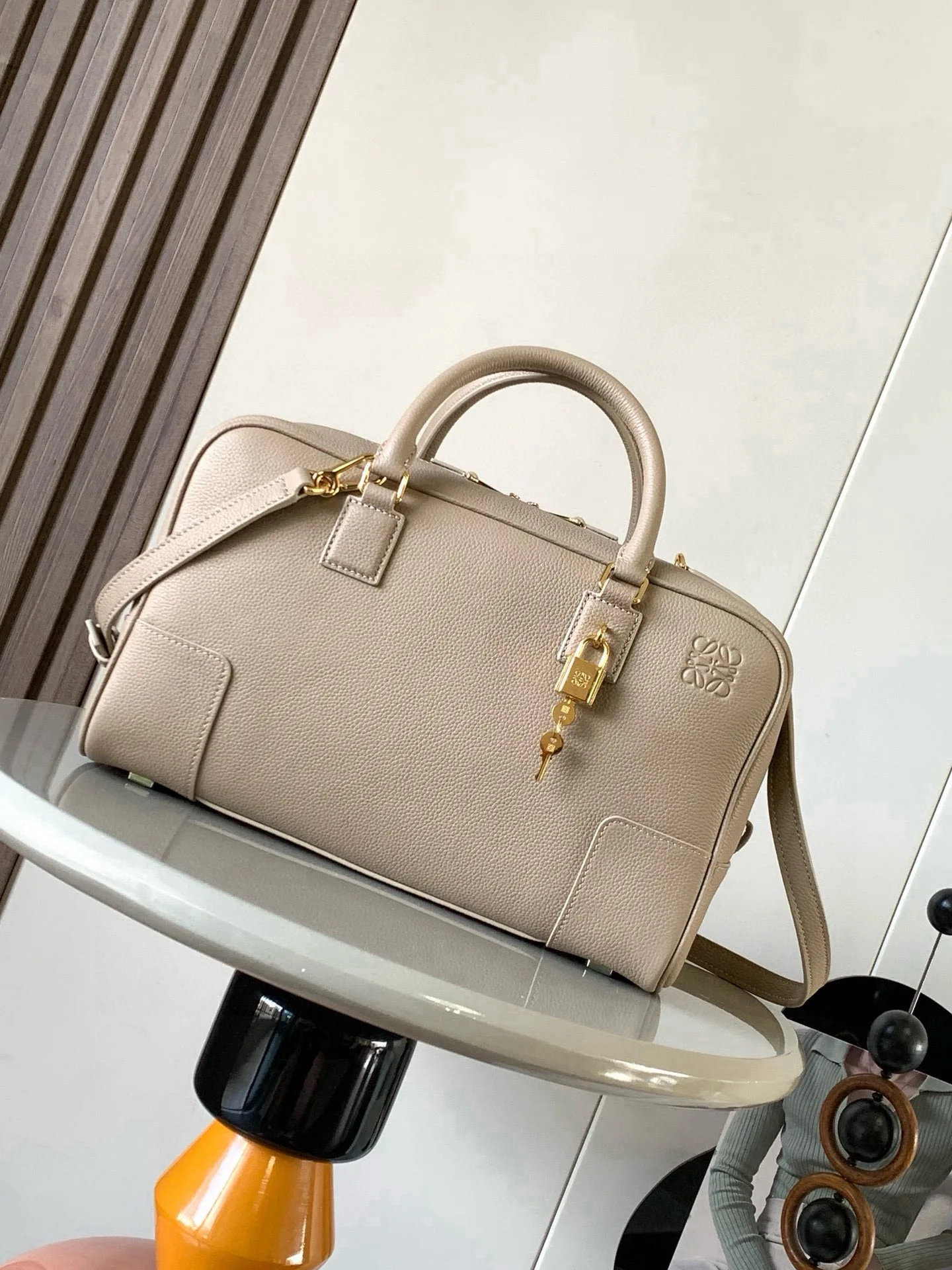 纳帕牛皮革 Amazona 28手袋Amazona 是 LOEWE 的标志性手袋 最初于1970年代作为顶部提手软结构手袋推出这款纳帕牛皮革版本更新了精致的比例和细节 包括一个 Anagram 雕刻挂锁 斜挎 肩背或顶部提手携带 可拆卸可调节肩带 双拉链开合 牛皮革拉链头 内部拉链隔层和按扣固定的插袋 用于存放挂锁钥匙的迷你口袋 底部保护性金属脚 可以使用肩带和个性化挂饰进行定制 金色绒面革衬里 Anagram 压纹尺寸 28cm 11cm 18cm款号 9080颜色 沙色荔