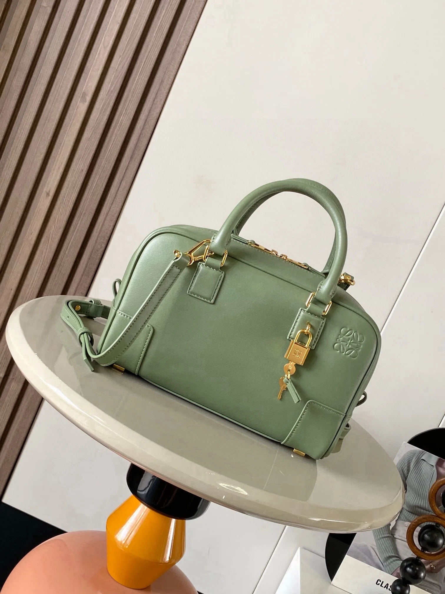 纳帕牛皮革 Amazona 23 手袋Amazona 是 LOEWE 的标志性手袋 最初于1970年代作为顶部提手软结构手袋推出这款纳帕牛皮革版本更新了精致的比例和细节 包括一个 Anagram 雕刻挂锁 斜挎 肩背或顶部提手携带 可拆卸可调节肩带 双拉链开合 牛皮革拉链头 内部拉链隔层和按扣固定的插袋 用于存放挂锁钥匙的迷你口袋 底部保护性金属脚 可以使用肩带和个性化挂饰进行定制 金色绒面革衬里  Anagram 压纹尺寸 23cm 10cm 15cm款号 9078颜色 绿色纹