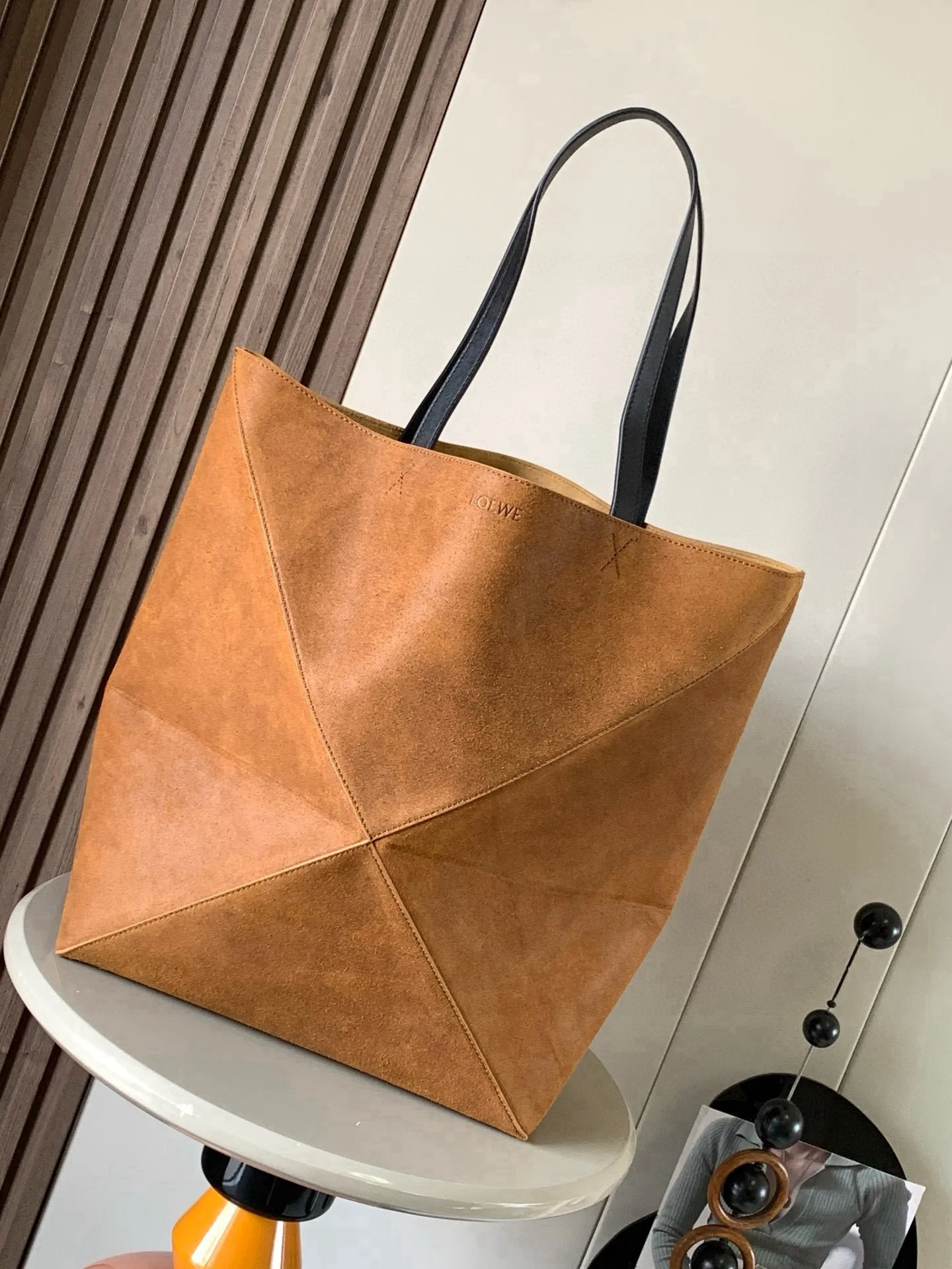 特大号压制绒面革 Puzzle Fold 手袋新品 Puzzle Fold 手袋从品牌经典手袋系列的几何线条汲取灵感以富含几何建筑美感的镶片重新诠释能完全折叠可谓旅行良伴品牌运用创意巧思打造柔软轻盈的手袋 搭配低调雅致的 LOEWE 罗意威品牌标志 此特大号版本采用压制绒面革制成搭配皮革饰边  可肩背或手提 绒面革衬里 压纹颜色 干邑色尺寸 42cm 18cm 41cm款号 9033