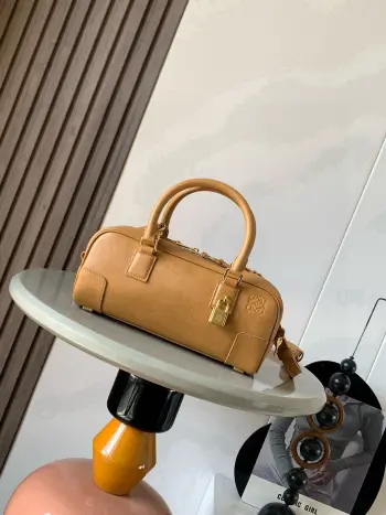 新款 明星同款手袋 Amazona 是 LOEWE 最初于1970年代推出的标志性手袋 采用精致比例和关键细节包括 Anagram 镌刻挂锁短款以纳帕牛皮革打造而成 可肩背 斜挎或手提 可拆卸可调节肩带 拉链开合 牛皮革拉链头 一个内部拉链隔层 一个插袋 一个挂锁钥匙收纳袋 包底以金属脚钉保护 金色绒面革衬里* Anagram 压纹尺寸 23cm 10cm 11cm款号 9085颜色 蜂蜜色