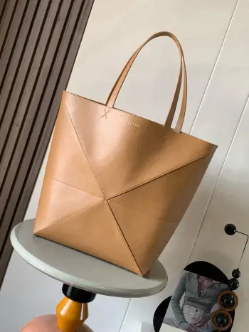 大号新款亮面牛皮革购物袋puzzle Fold手袋大号几何图形玩出花了  很久没见过这么实用又设计感满满的托特包了这款延续了Puzzle系列的几何美学以折纸包为灵感 让这只 Puzzle Fold tote 在立体和平面随意切换 上身了两个尺码给大家参考哦大号容量更友好 小号很可爱 皮质都很细腻光泽本身自重超轻 能完全折叠是旅行良伴 这个大号版本采用柔软的亮面牛皮革打造尺寸 42CM 41CM 18CM款号 9033颜色 暖沙黄