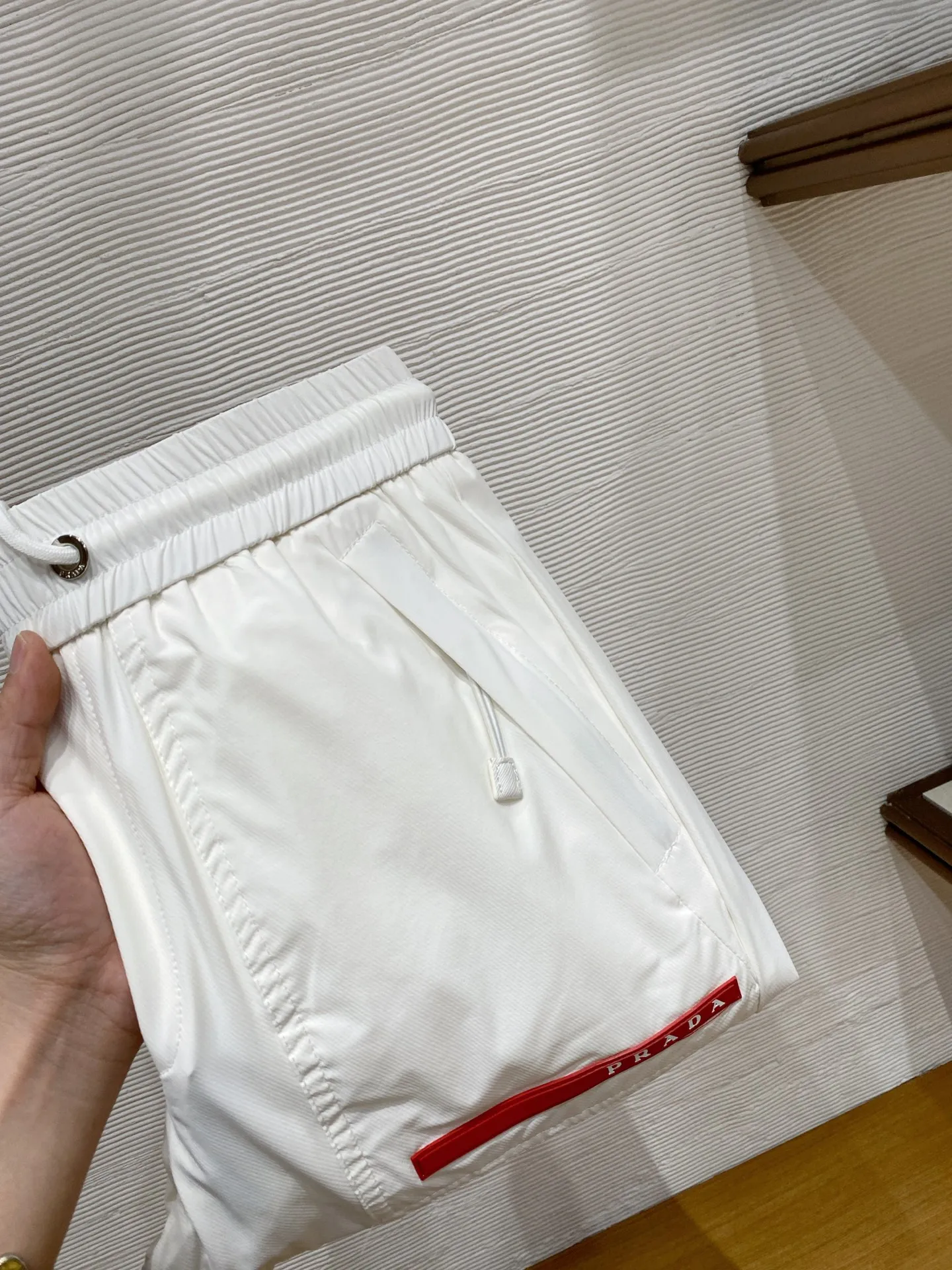 原单休闲裤男装|高仿休闲裤男装|精仿休闲裤男装|一比一休闲裤男装PRD  26SS春夏科技面料抽绳束脚裤男士铭牌时尚运动休闲长裤 贸易公司渠道稀出 领先官网发售 在这个追求个性与品质的时代 你是否渴望拥有一款既展现身份地位 又充满运动风格的裤子 新款慢跑裤将是你的最佳选择 这款裤子选用了客供定制的科技面料 质地轻薄丝滑 触感舒爽透气 仿佛给肌肤带来一股清凉的冰感 在炎炎夏日 穿上它将感受到前所未有的舒适与惬意 设计上独具匠心 展现出不凡的品质感 这些细节的处理 都充分体现了品牌对品质的极致追求 客供定制的五金辅料均刻有品牌Logo 细节无法挑剔 抽绳松紧裤腰和裤脚罗纹拼接束口设计 使这款裤子既适合休闲场合 也能应对运动时刻 颜色 黑色 白色尺码 M-3XL尺寸参考 M码 腰围72臀围104大腿围60裤长99L码 腰围76臀围108大腿围62裤长100XL码 腰围80臀围112大腿围64裤长1012XL码 腰围84臀围116大腿围66裤长1023XL码 腰围88臀围120大腿围68裤长103