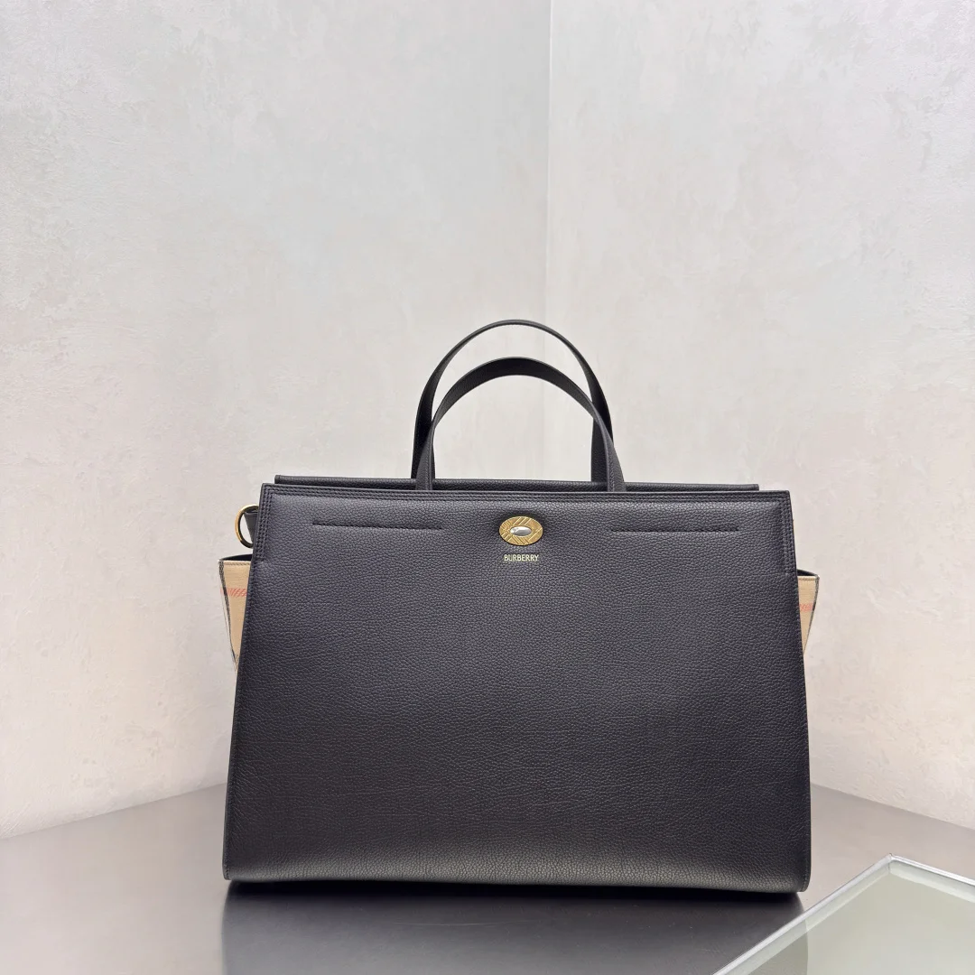 Cotswolds 格纹托特包 选用粒纹小牛皮材质打造 设有 Burberry 格纹侧边裁片 搭配同设计标志性沙米色内衬 精巧款式 内部空问充裕 融入格纹镌纹开合与D型环配件 灵感源自品牌标志性 Trench 风衣腰带 可手拿携带 或使用肩背带缔造肩背造型 尺寸39.5×17x 28.5cm型号0411