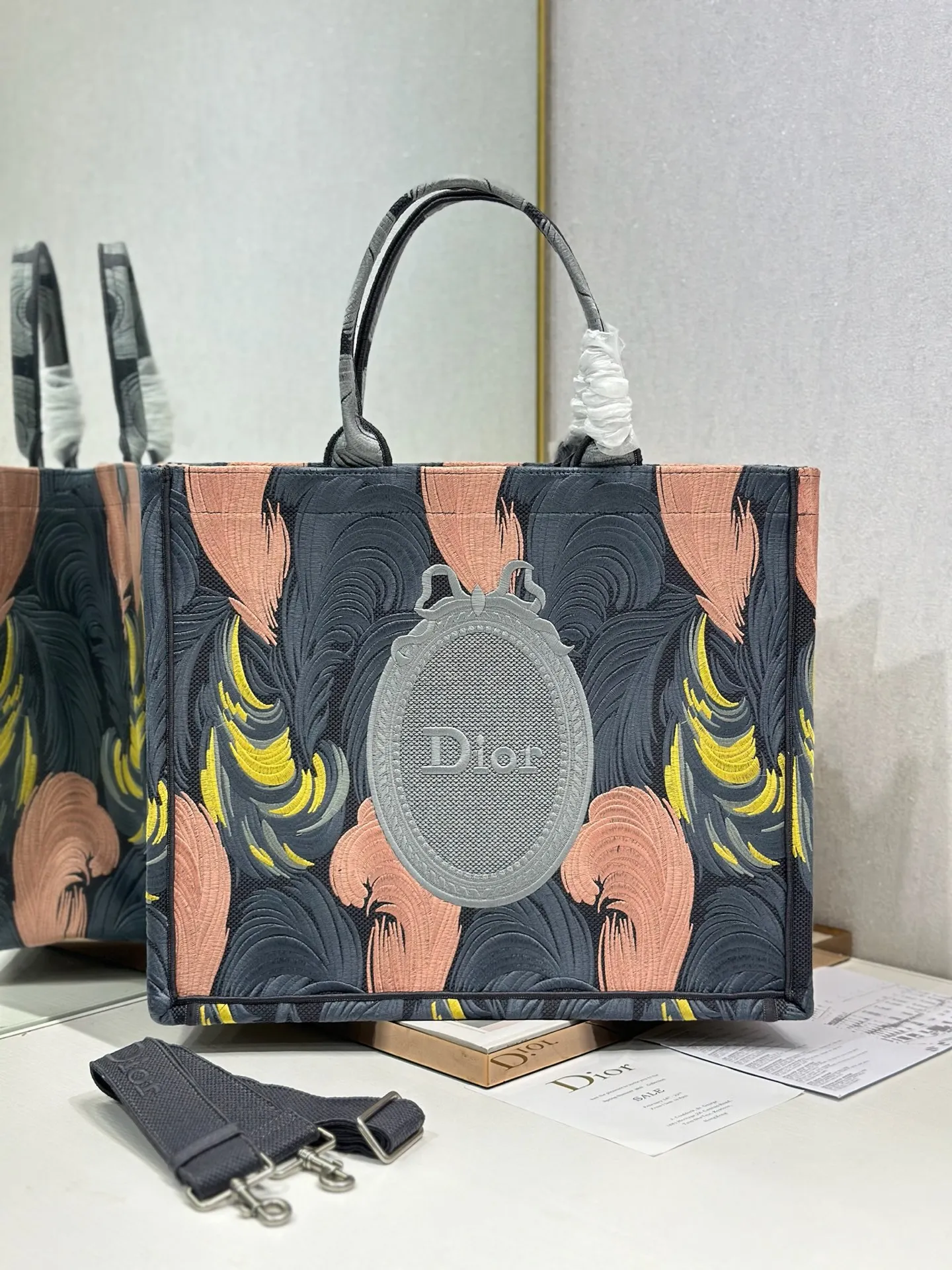  羽毛镜子配肩带 大号 Dior book tote 购物袋这款Book Tote手袋灵感来自女装创意总监玛丽亚 嘉茜娅 蔻丽 Maria Grazia Chiuri 是体现Dior审美的主打产品 可收纳各种日常用品 全新演绎Bayadere图案混合效果D-Stripes图案刺绣 更具时尚风范 正面饰以 Christian Dior 标志 充分体现了Dior的精湛工艺 款号 1286尺寸 42×35×18.5cm