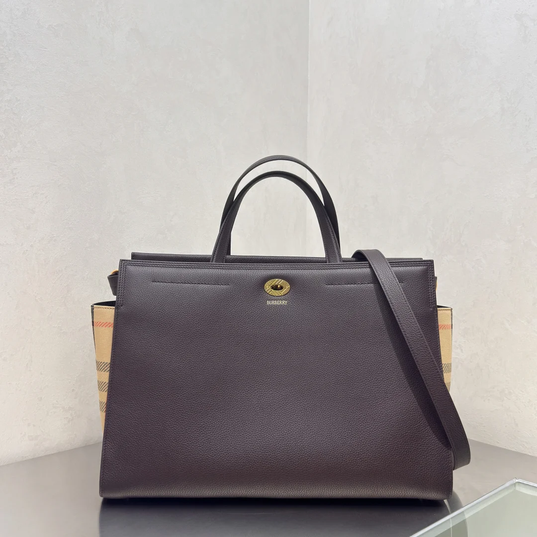 特级 Cotswolds 格纹托特包 选用粒纹小牛皮材质打造 设有 Burberry 格纹侧边裁片 搭配同设计标志性沙米色内衬 精巧款式 内部空问充裕 融入格纹镌纹开合与D型环配件 灵感源自品牌标志性 Trench 风衣腰带 可手拿携带 或使用肩背带缔造肩背造型 尺寸39.5×17x 28.5cm型号0411