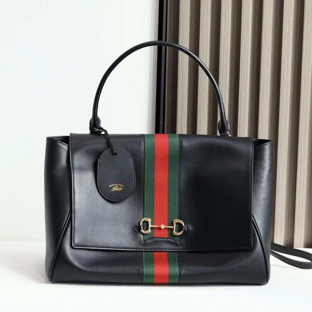 Generation Gucci系列深入探索品牌的典藏元素将不同年代的设计融合成一种美学叙事 这款手提包采用顶部手柄设计 以柔软皮革打造 向品牌标志性的Horsebit和Web致敬 黑色软皮黑色皮革滚边金色调配件黑色帆布衬里 饰Diamante图案Horsebit 网状结构和皮革标牌 带有 Made in Italy Gucci 标志内部 1个拉链口袋手挽垂直长度 18 - 24.5厘米可拆卸和可调节皮革肩带长度 51 - 55cm按扣磁扣开合型号 875019 尺寸 37厘米 宽 x 29厘米 高 x 13厘米 深 重量 约825克颜色 黑色/全皮 意大利创作