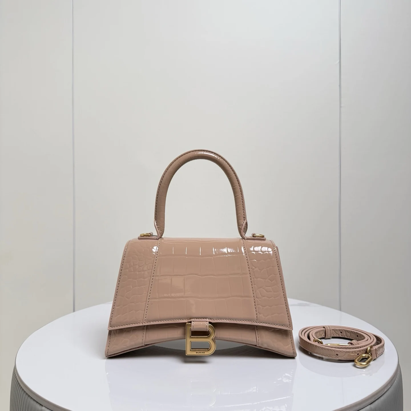 S大号23cm 鳄鱼裸粉配金扣 只做好品质Balenciag 巴黎.世家 经典款沙漏包.独特的标志性弧线形状造型极具辨识度 外观呈现一轮半月状上坠一个金属B形拉环牛皮质感也非常有腔调 内里进口羊皮细腻柔软的质感 手拎斜挎都好看到爆 女神们的最爱 容量亲测 手机 零包 粉饼 口红 钥匙 小包纸巾 轻松收纳尺寸 23x10x24cm 货号188001