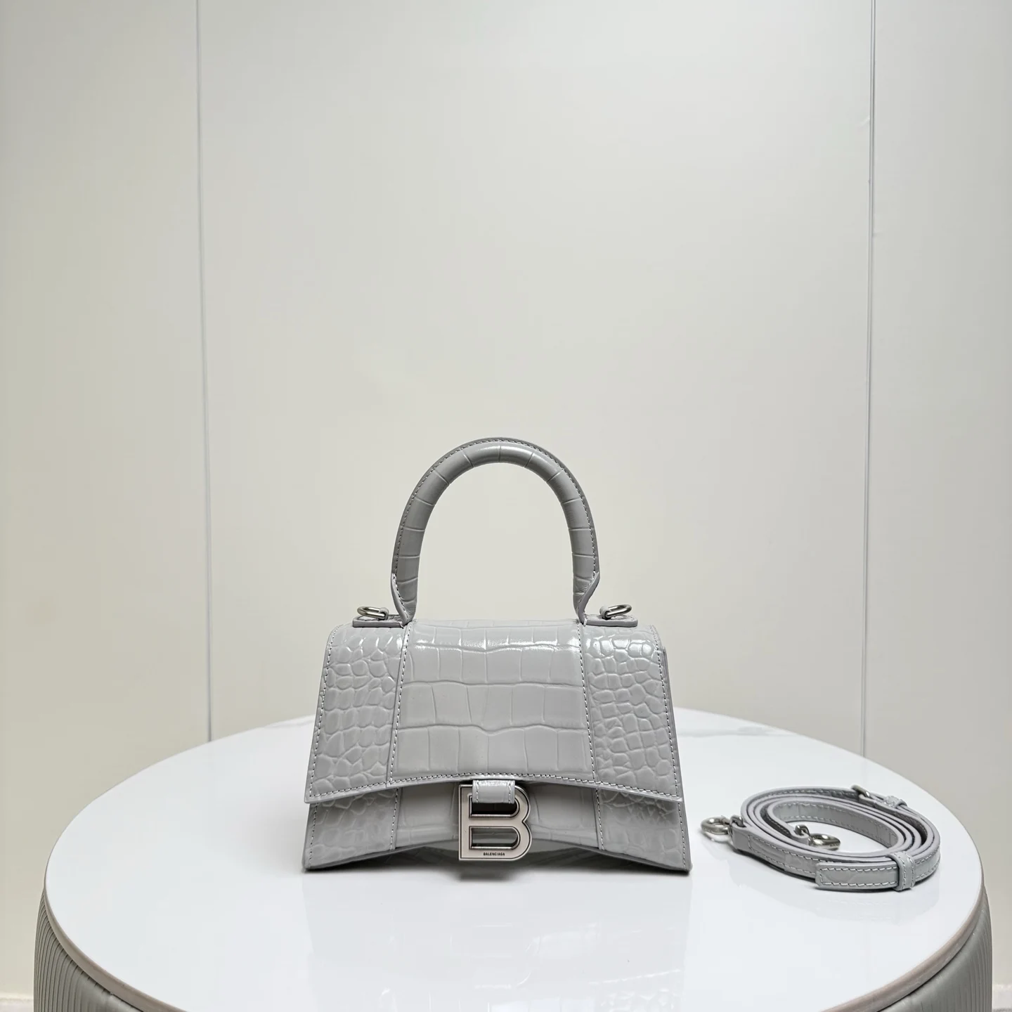 XS小号19cm 鳄鱼灰色配银扣 只做好品质Balenciag 巴黎.世家 经典款沙漏包.独特的标志性弧线形状造型极具辨识度 外观呈现一轮半月状上坠一个金属B形拉环牛皮质感也非常有腔调 内里进口羊皮细腻柔软的质感 手拎斜挎都好看到爆 女神们的最爱 容量亲测 手机 零包 粉饼 口红 钥匙 小包纸巾 轻松收纳尺寸:19x8x21cm 货号188002
