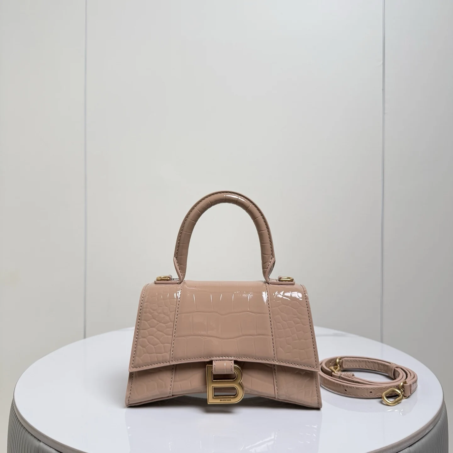 XS小号19cm 鳄鱼裸粉配金扣 只做好品质Balenciag 巴黎.世家 经典款沙漏包.独特的标志性弧线形状造型极具辨识度 外观呈现一轮半月状上坠一个金属B形拉环牛皮质感也非常有腔调 内里进口羊皮细腻柔软的质感 手拎斜挎都好看到爆 女神们的最爱 容量亲测 手机 零包 粉饼 口红 钥匙 小包纸巾 轻松收纳尺寸:19x8x21cm 货号188002