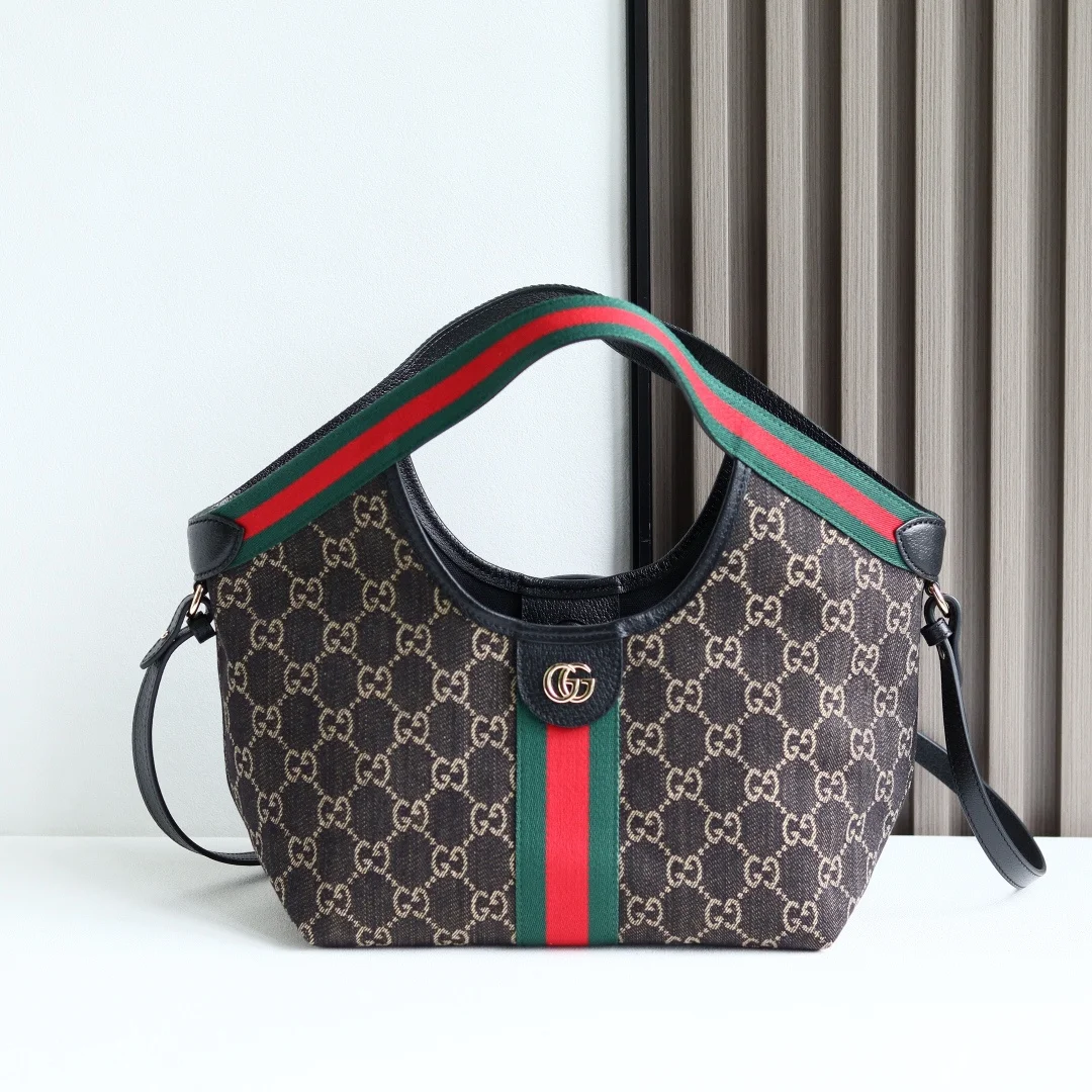 新品 GG系列推出小号版本 这款托特包亮相于品牌在佛罗伦萨发布的2026早春时装秀 致敬品牌意大利根源 彰显传承与革新精神 空间宽敞的设计以GG帆布面料匠心打造 饰以织带滚边 配有可拆卸手拿包 更添时尚魅力 型号860845材质 克色丹宁牛仔GG帆布深棕色皮革滚边红绿织带细节尼龙衬里 绿色亚麻棉混纺衬里 尺寸25x20x15cm