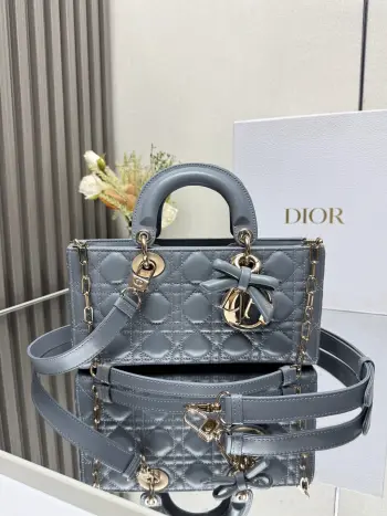 中号 LADY D-JOY 手袋 雾霾蓝带蝴蝶结小羊皮 这款 Lady D-Joy 手袋凸显 Lady Dior 系列的简约美学 集中体现了 Dior 对典雅和美丽的深刻洞见 采用黑色哑光牛皮革精心制作 以经典的藤格纹缉面线打造醒目的绗缝细节 精良的缝制工艺显露无遗 同色调金属 D.I.O.R. 吊饰彰显优雅气质 小号款式 搭配可拆卸的链条肩带和可调节 可拆卸的皮革肩带 可手提 肩背或斜挎 是日常造型的理想之选 可拆卸链条肩带可拆卸 可调节的皮革肩带型号 0540尺寸 26×13.5×5 cm可收纳一部 iPhone和其他配饰238620