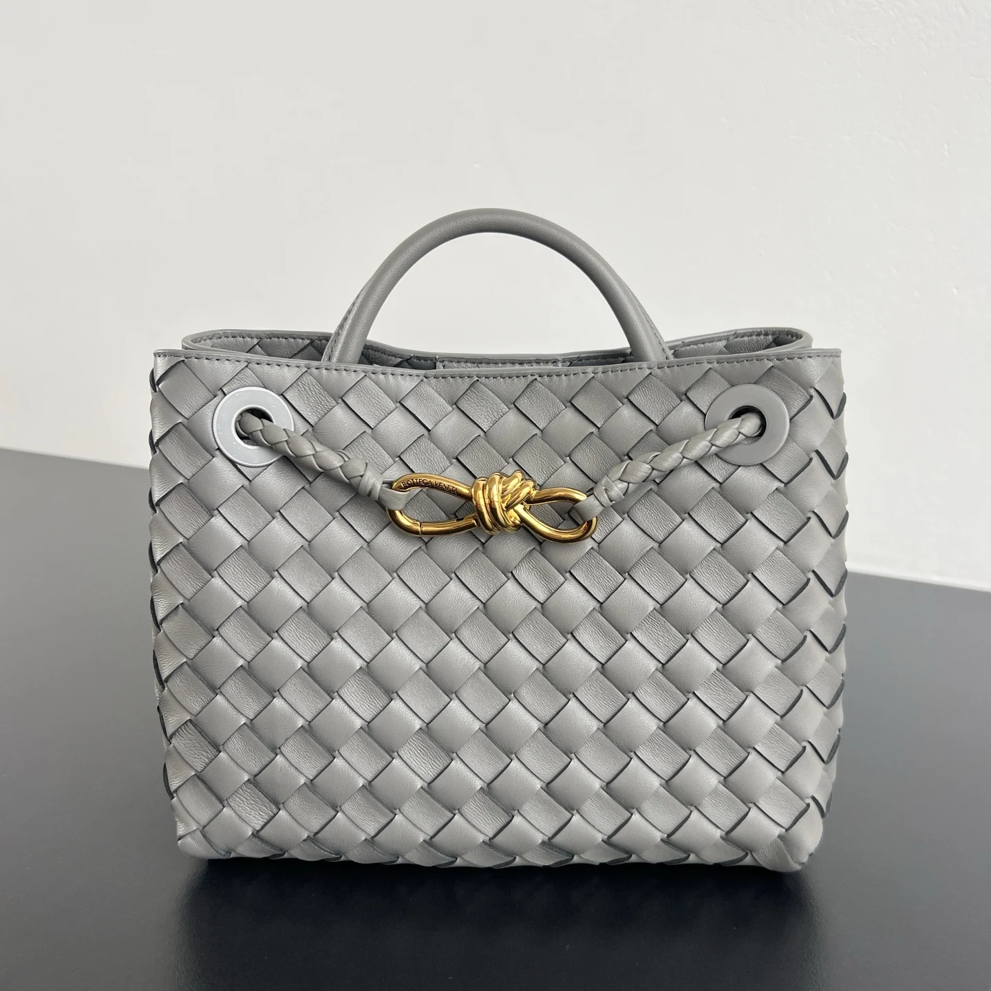 Bottega Veneta 2023春夏新款Andiamo手袋 众多明星同款 743568 经典的全身皮革编织搭配金色绳结扣 够沉稳也够潇洒整体皆由Nappa羊皮革制成 舒适柔软且富有动感 可滑动的金属绳结扣可以调整肩带 单肩/手伶/斜挎 多种背法 包身容量大 通勤/日常/出游都很合适 这款包分为小号/中号 /大号 总有一款适合你 那就带我走叭 尺寸:25x22x10.5