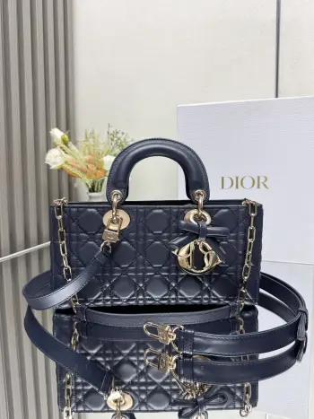 中号 LADY D-JOY 手袋 深蓝色带蝴蝶结小羊皮 这款 Lady D-Joy 手袋凸显 Lady Dior 系列的简约美学 集中体现了 Dior 对典雅和美丽的深刻洞见 采用黑色哑光牛皮革精心制作 以经典的藤格纹缉面线打造醒目的绗缝细节 精良的缝制工艺显露无遗 同色调金属 D.I.O.R. 吊饰彰显优雅气质 小号款式 搭配可拆卸的链条肩带和可调节 可拆卸的皮革肩带 可手提 肩背或斜挎 是日常造型的理想之选 可拆卸链条肩带可拆卸 可调节的皮革肩带型号 0540尺寸 26×13.5×5 cm可收纳一部 iPhone和其他配饰238620