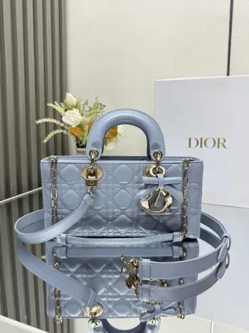 中号 LADY D-JOY 手袋 淡蓝色带蝴蝶结小羊皮 这款 Lady D-Joy 手袋凸显 Lady Dior 系列的简约美学 集中体现了 Dior 对典雅和美丽的深刻洞见 采用黑色哑光牛皮革精心制作 以经典的藤格纹缉面线打造醒目的绗缝细节 精良的缝制工艺显露无遗 同色调金属 D.I.O.R. 吊饰彰显优雅气质 小号款式 搭配可拆卸的链条肩带和可调节 可拆卸的皮革肩带 可手提 肩背或斜挎 是日常造型的理想之选 可拆卸链条肩带可拆卸 可调节的皮革肩带型号 0540尺寸 26×13.5×5 cm可收纳一部 iPhone和其他配饰238620