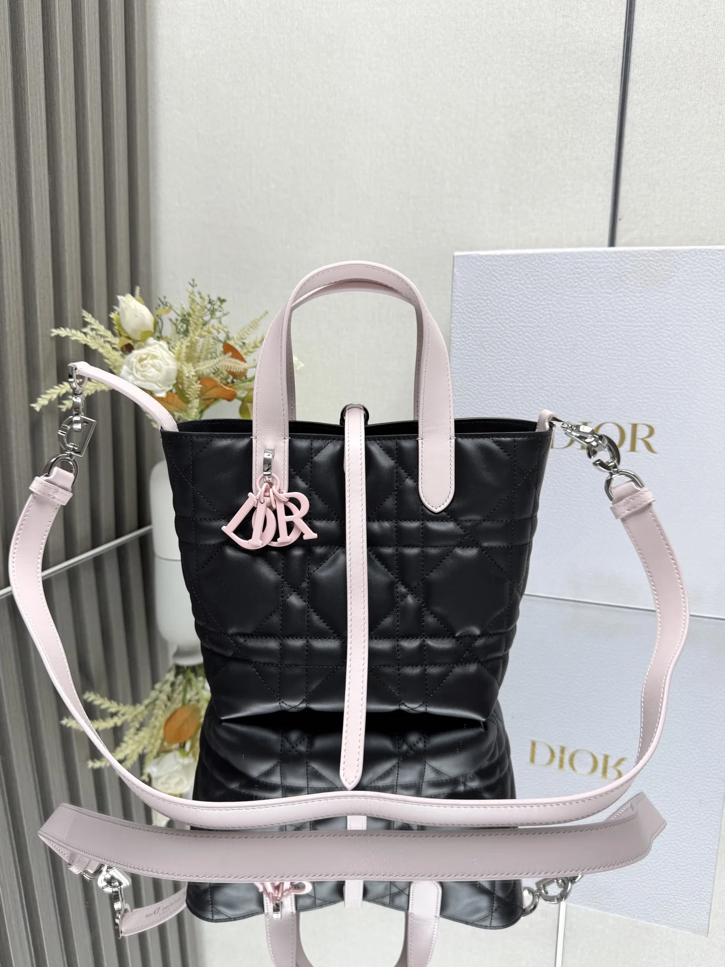 这款 Dior Toujours竖版手袋是二零二五早春成衣系列新品 时尚实用 别具一格 采用黑配粉色牛皮革精心制作 饰以超大藤格纹缉面线 宽敞的内部隔层可收纳各种日常用品 设有纤细皮革系带开合 可安全收纳各种物品 另有CD Lock 字母D旋钮式扣环 可调节两侧 提升格调 小号款式 顶部皮革手柄搭配可拆卸的皮革肩带 可手提 肩背或斜挎主体:牛皮革里料:牛皮革尺寸 16×18×12cm 款号 2835