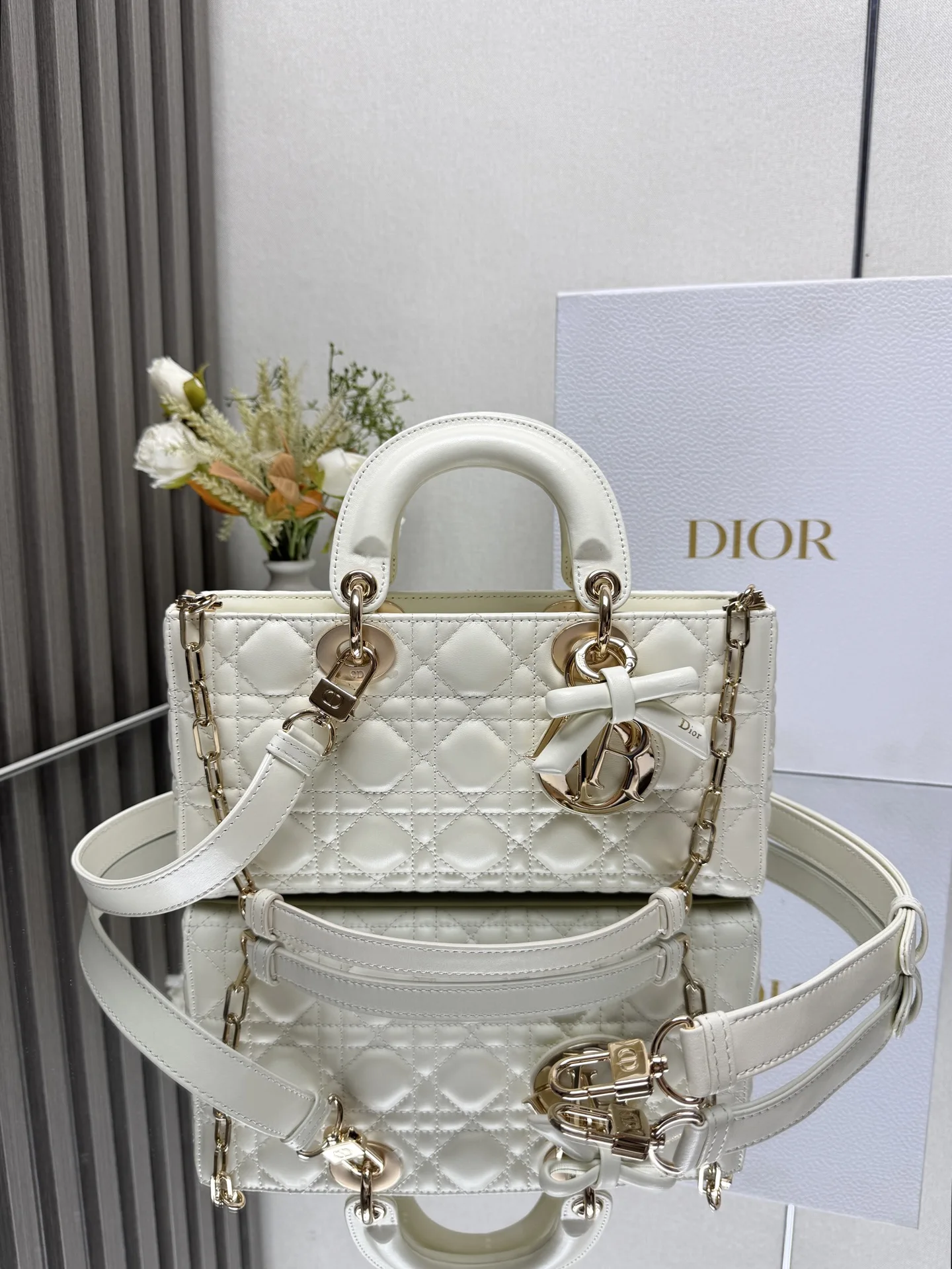 原单迪奥女包|高仿迪奥女包|精仿迪奥女包|一比一迪奥女包中号 LADY D-JOY 手袋 白色带蝴蝶结小羊皮 这款 Lady D-Joy 手袋凸显 Lady Dior 系列的简约美学 集中体现了 Dior 对典雅和美丽的深刻洞见 采用黑色哑光牛皮革精心制作 以经典的藤格纹缉面线打造醒目的绗缝细节 精良的缝制工艺显露无遗 同色调金属 D.I.O.R. 吊饰彰显优雅气质 小号款式 搭配可拆卸的链条肩带和可调节 可拆卸的皮革肩带 可手提 肩背或斜挎 是日常造型的理想之选 可拆卸链条肩带可拆卸 可调节的皮革肩带型号 0540尺寸 26×13.5×5 cm可收纳一部 iPhone和其他配饰238620